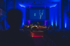 Scena oświetlona w niebieskich barwach, na ekranie obrazy z Zabytkowej Kopalni Srebra