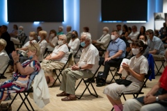 Publiczność zgromadzona w Łaźni, siedząca na krzesłach, w maseczkach zakrywających nos i usta