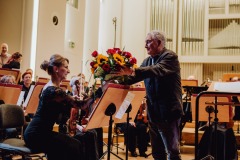 Kompozytor (Zygmunt Krauze) przekazujący kwiaty koncertmistrzyni