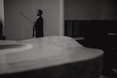 Czarno-białe zdjęcie skrzypka oczekującego na wejście na scenę