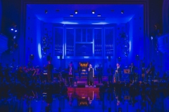 Muzycy na scenie oświetlonej w niebieskich barwach