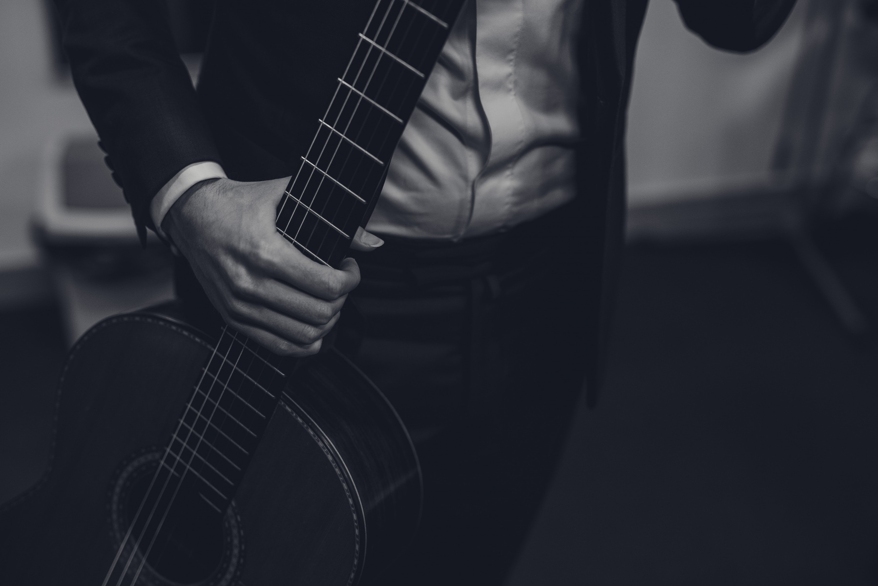 Czarno-białe zdjęcie. Gitara w rękach solisty