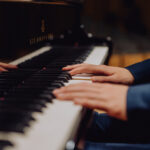 Dłonie na klawiaturze fortepianu